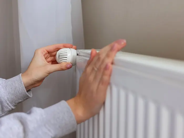 Eine Hand an einer Heizung.
