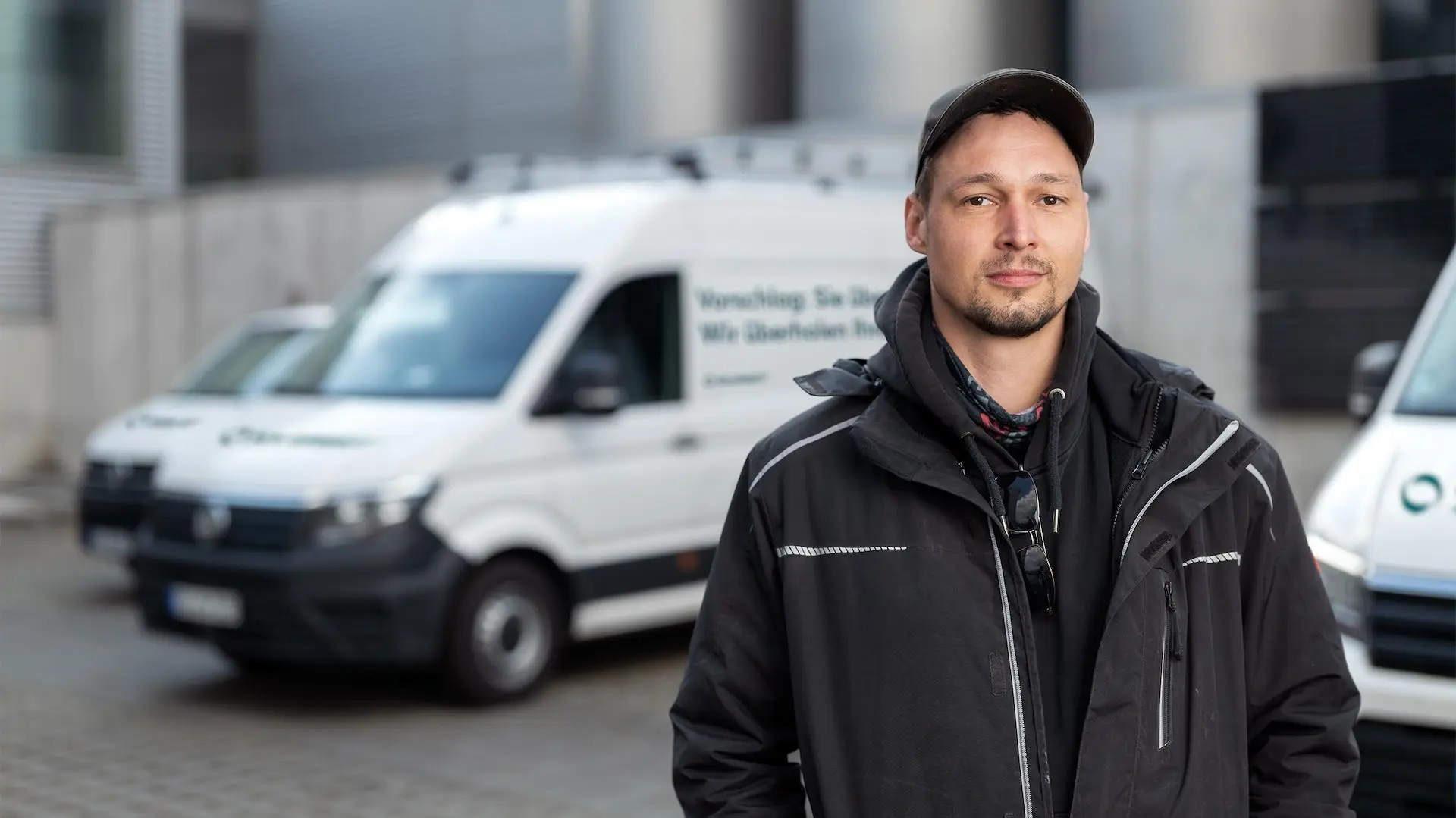Solarwatt-Installateur vor dem Firmentransporter