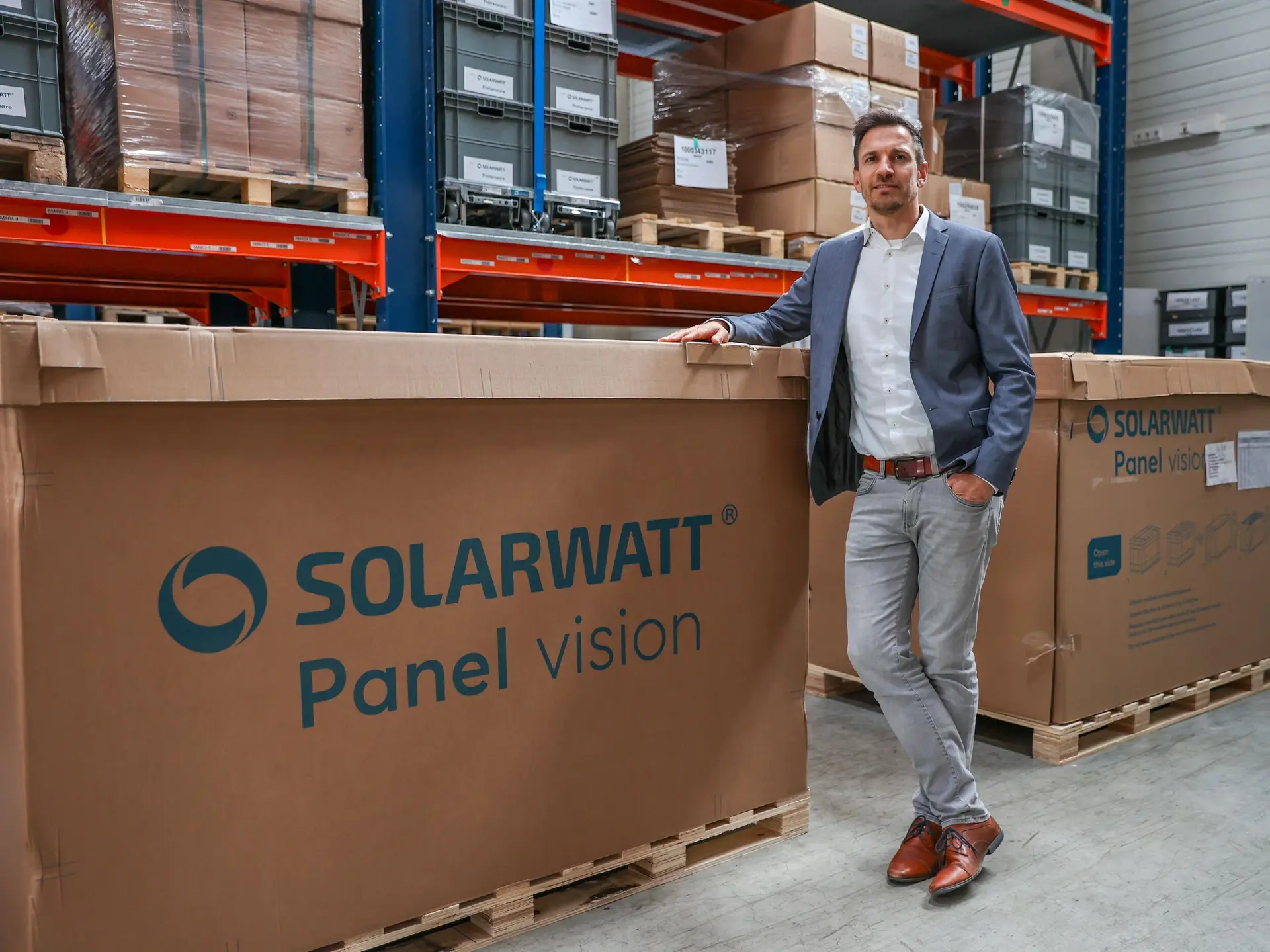Gregor Kuschmann vor einer Palette SOLARWATT Panel vision.