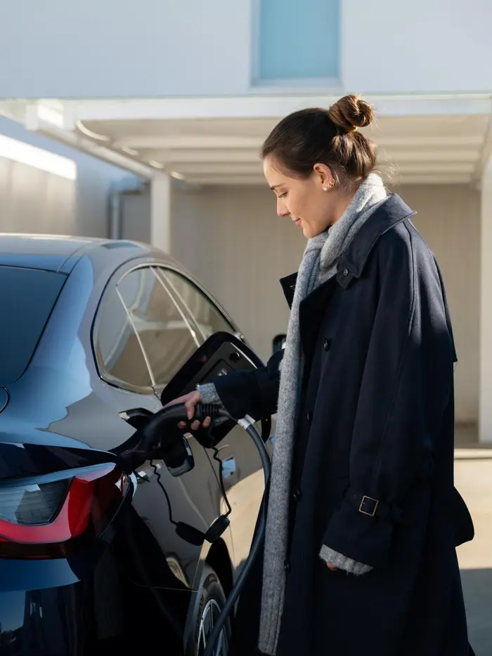 Eine Frau lädt ein E-Auto.