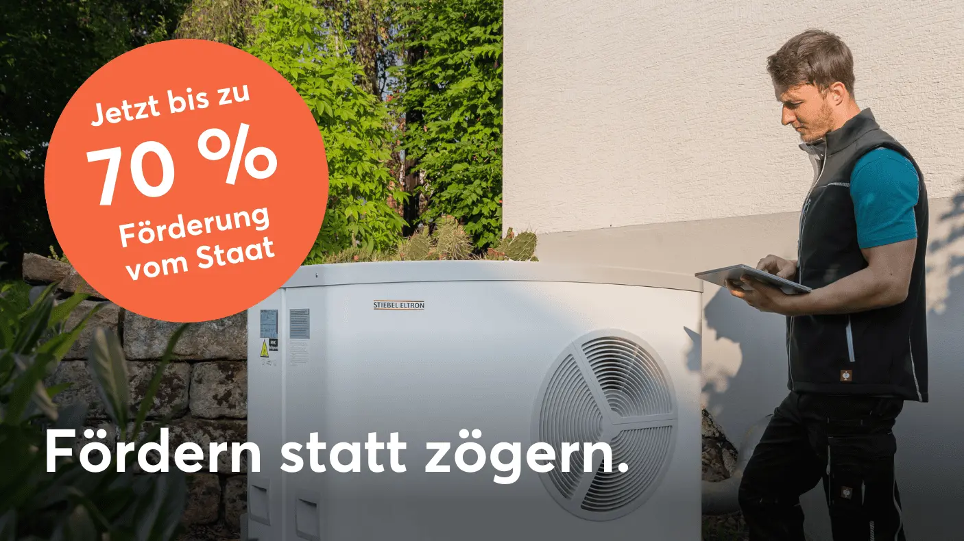 Ein Installateur vor einer Wärmepumpe-