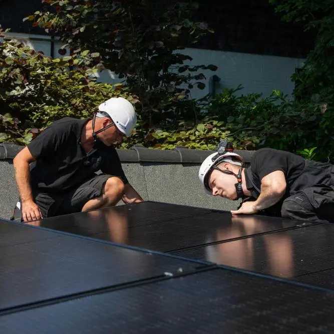 Installateure arbeiten an Solarmodulen