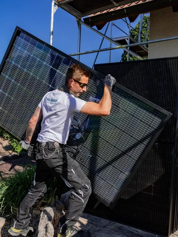 Solarwatt-Installateur trägt Solarmodul