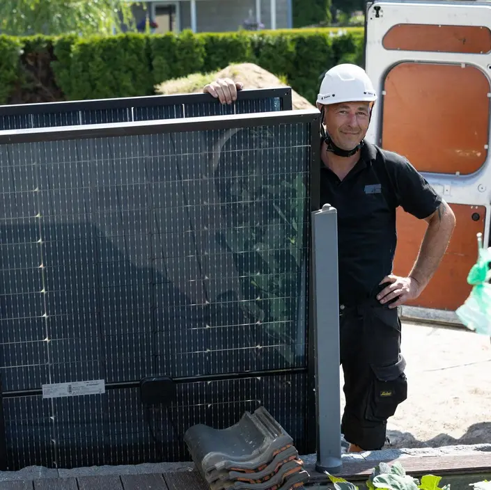 Installateur neben einem Solarmodul