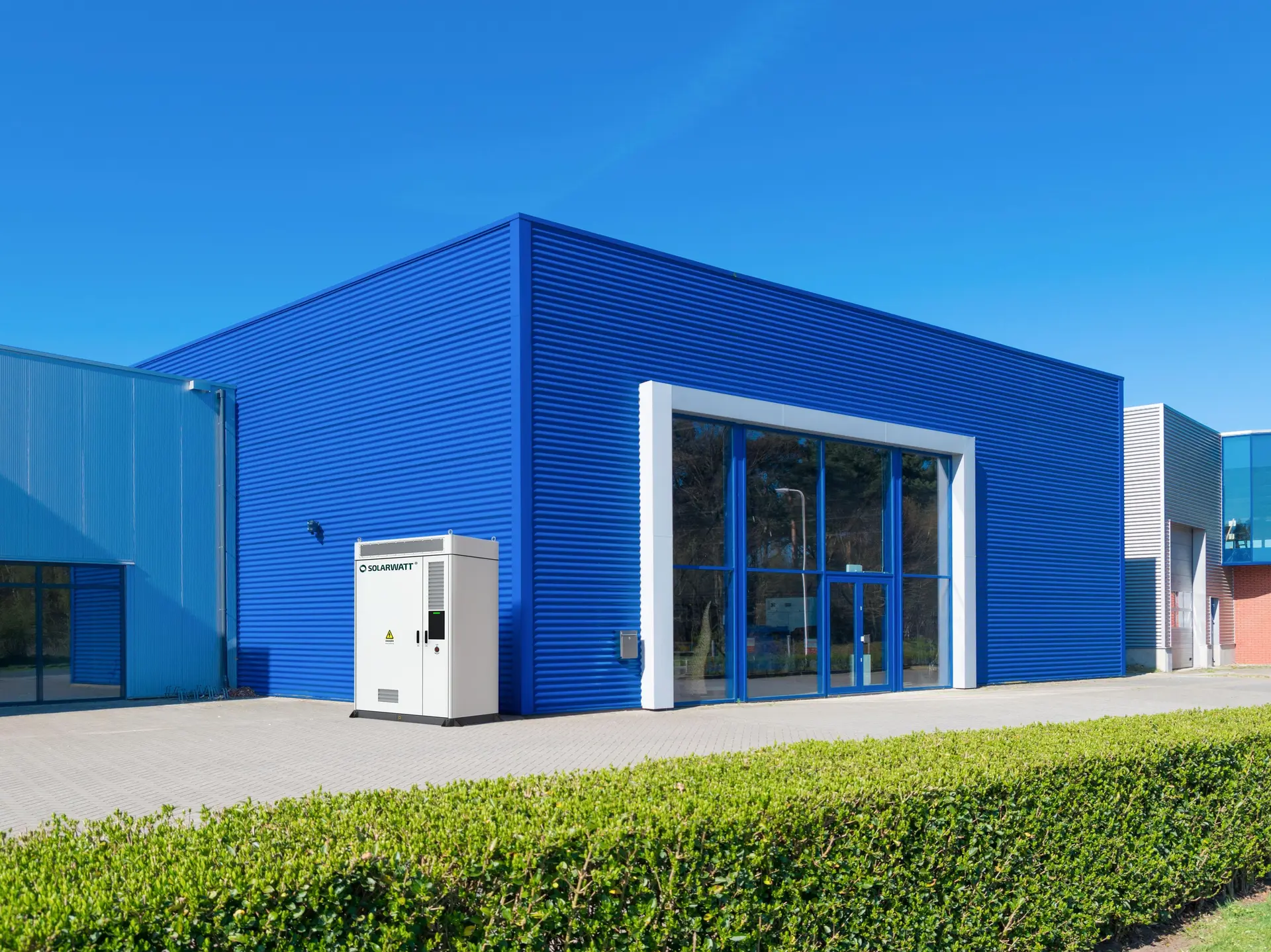 Gewerbespeicher von Solarwatt vor einem Firmengebäude