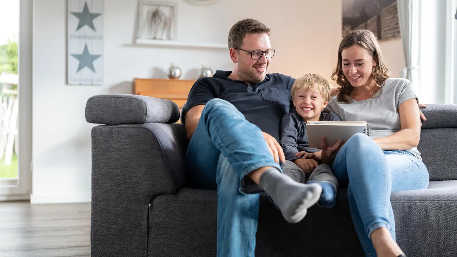 Eine Familie sitzt zusammen auf dem Sofa.