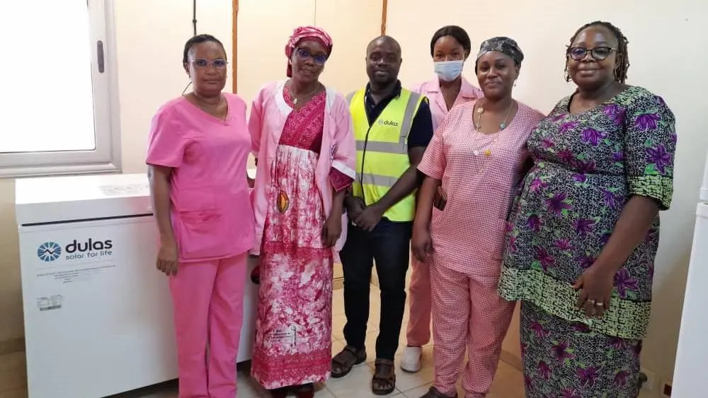 Dulas refrigerator installation in Burkina Faso, with local community members gathered in front of it.