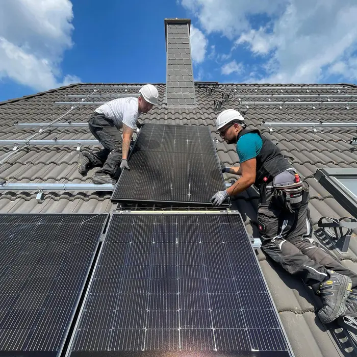 Solarwatt-Mitarbeiter arbeiten auf dem Dach an der Installation einer Solaranlage