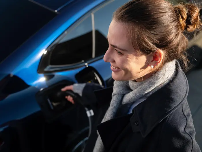 Frau lädt ein E-Auto mit einer Wallbox