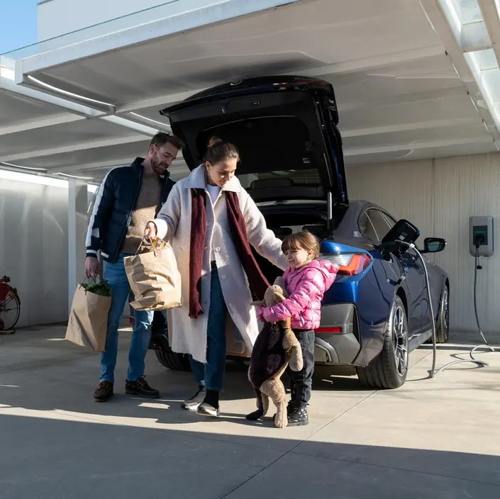Eine Familie vor einem E-Auto.