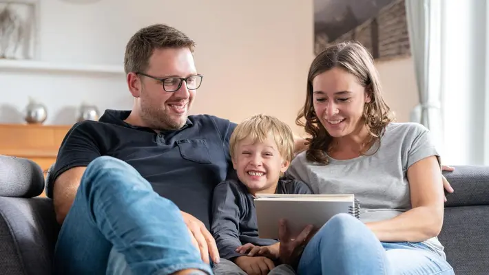 Eine Familie sitzt zusammen auf dem Sofa.
