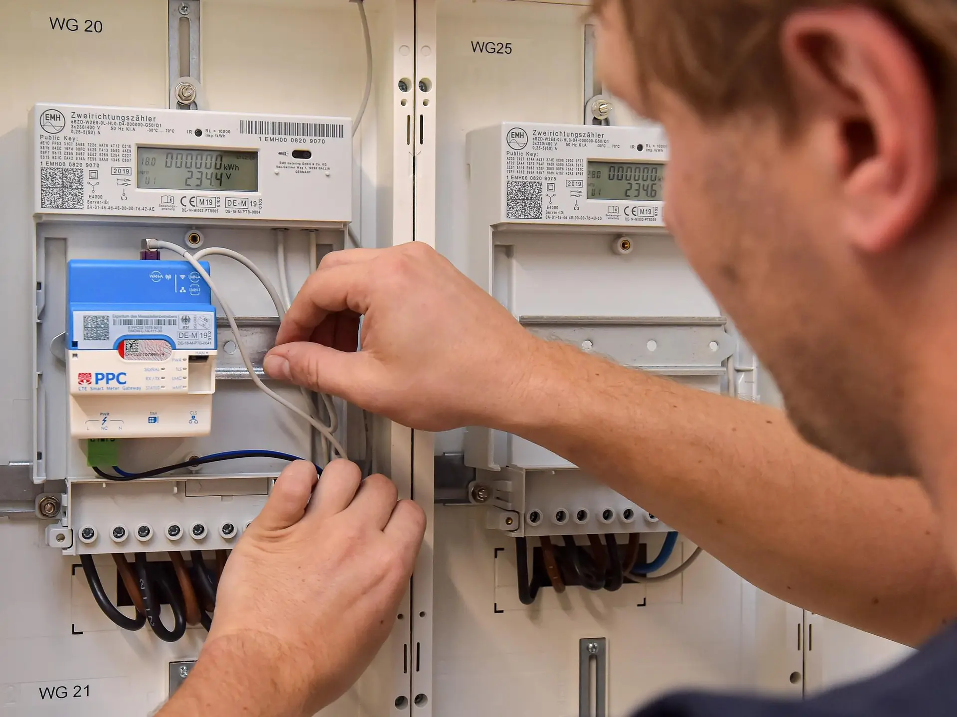 Mensch verbindet Kabel an einem Smart Meter