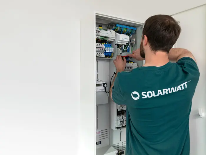 SOLARWATT-Mitarbeiter beim Anschluss des Smart Meter