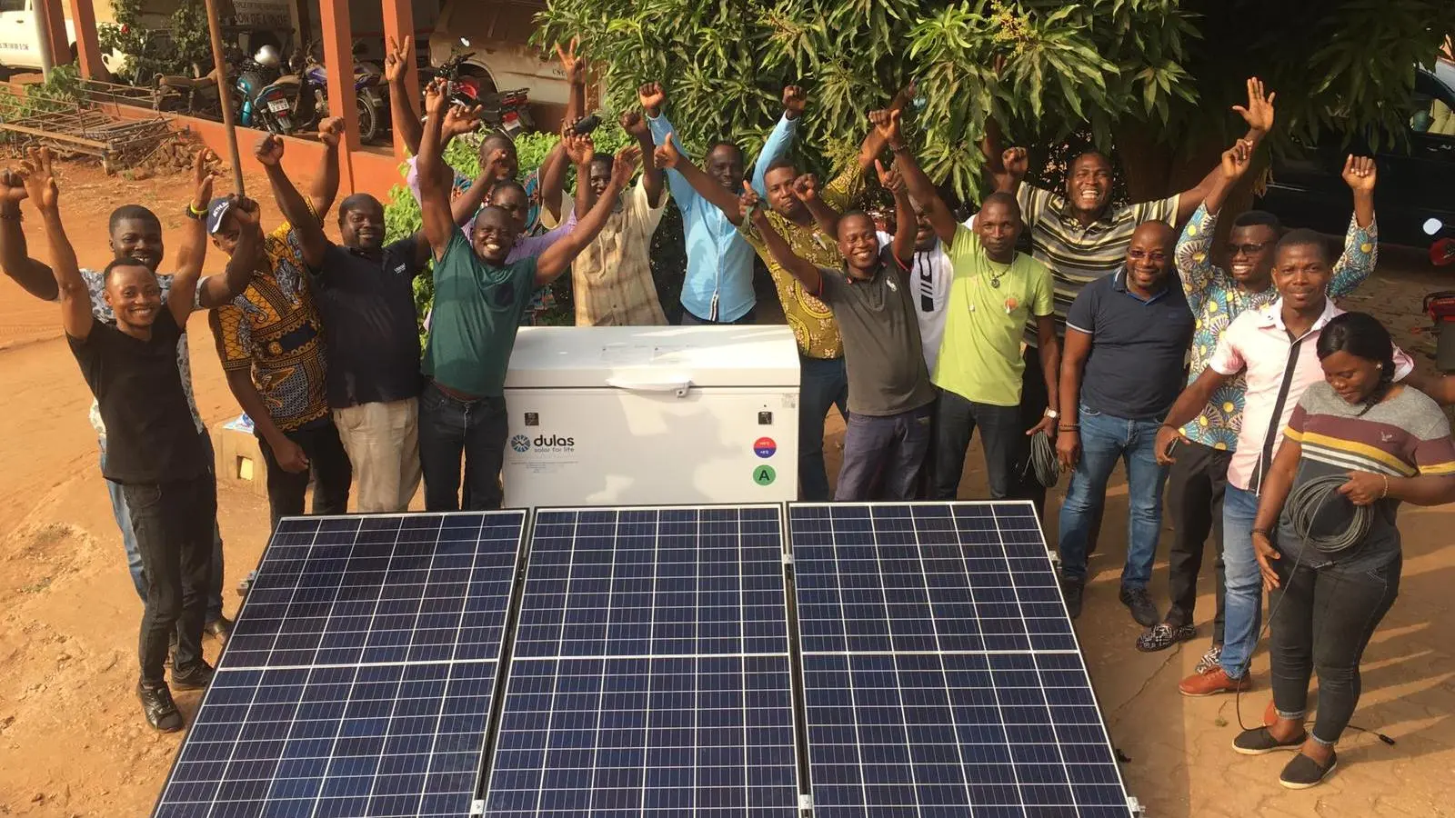 Dulas solar direct-drive refrigeration unit installation in Benin, surrounded by community members.