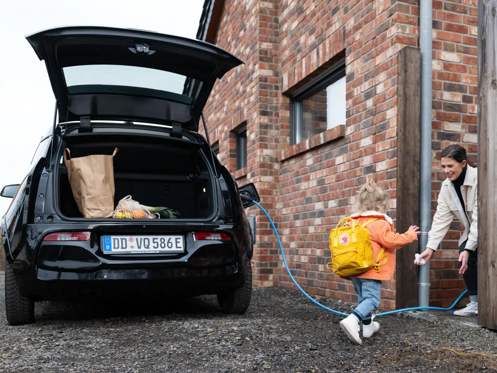 Familie an ladendem E-Auto