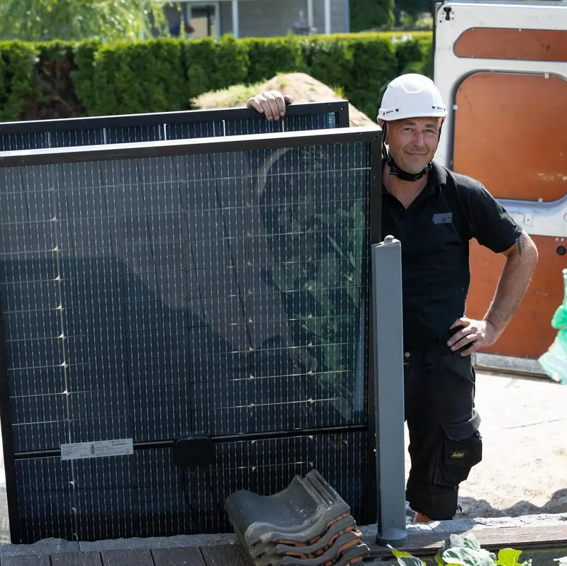 Solarwatt-Installateur hält ein Solarmodul.