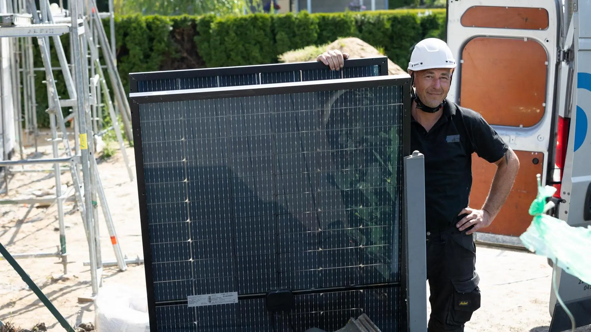 Solarwatt-Installateur hält ein Solarmodul.