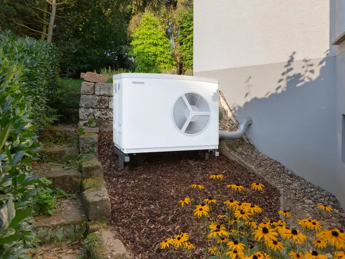 STIEBEL ELTRON white air-source heat pump down the side of a house