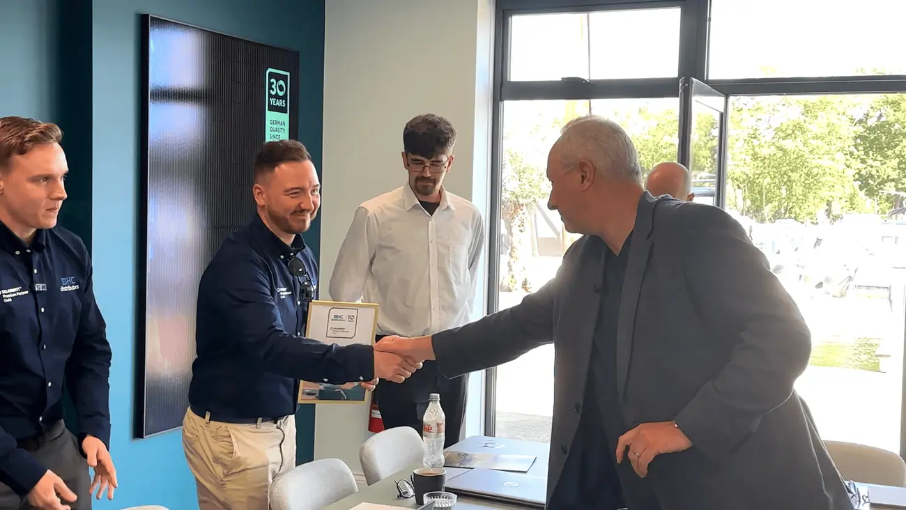 Photograph of Neil McKee (BHC Distributors) accepts the Premium Partner GOLD award from Neal Goddard (SOLARWATT)