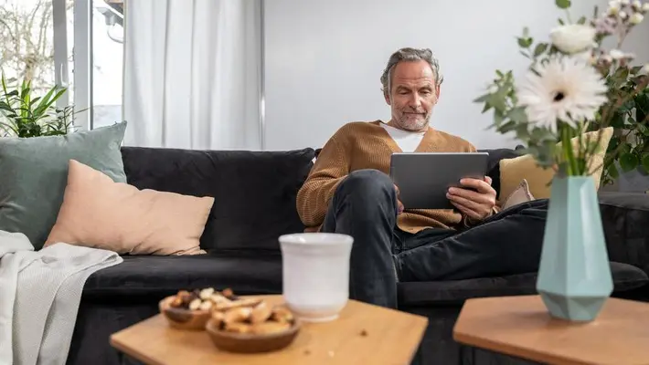 Mann schaut auf Tablet