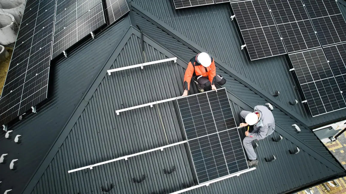 Installateure installieren eine PV-Anlage auf einem Dach